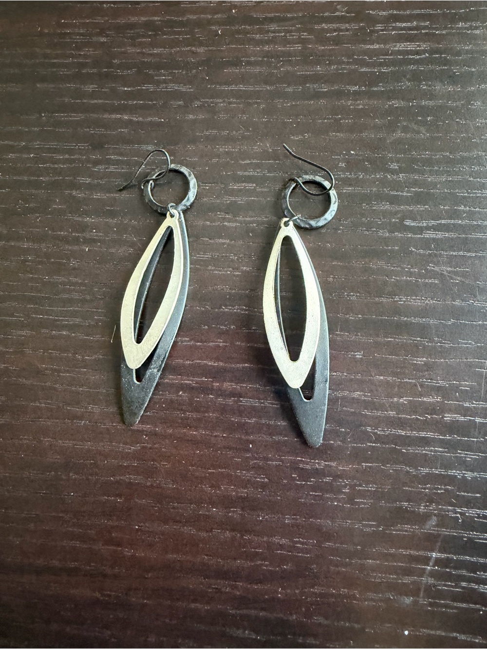 Two-tone dangle earrings featuring a layered, elongated pointed oval design